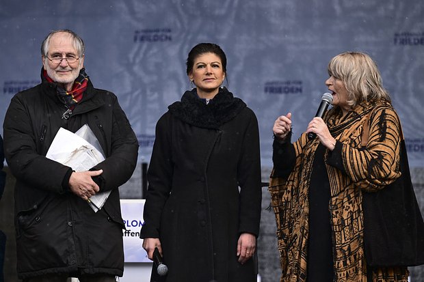 Массовая демонстрация в поддержку начала мирных переговоров с Россией, организованная левым политиком Сарой Вагенкнехт (в центре) и активисткой за права женщин Алисой Шварцер (справа) у Бранденбургских ворот в Берлине, 25 февраля 2023 года