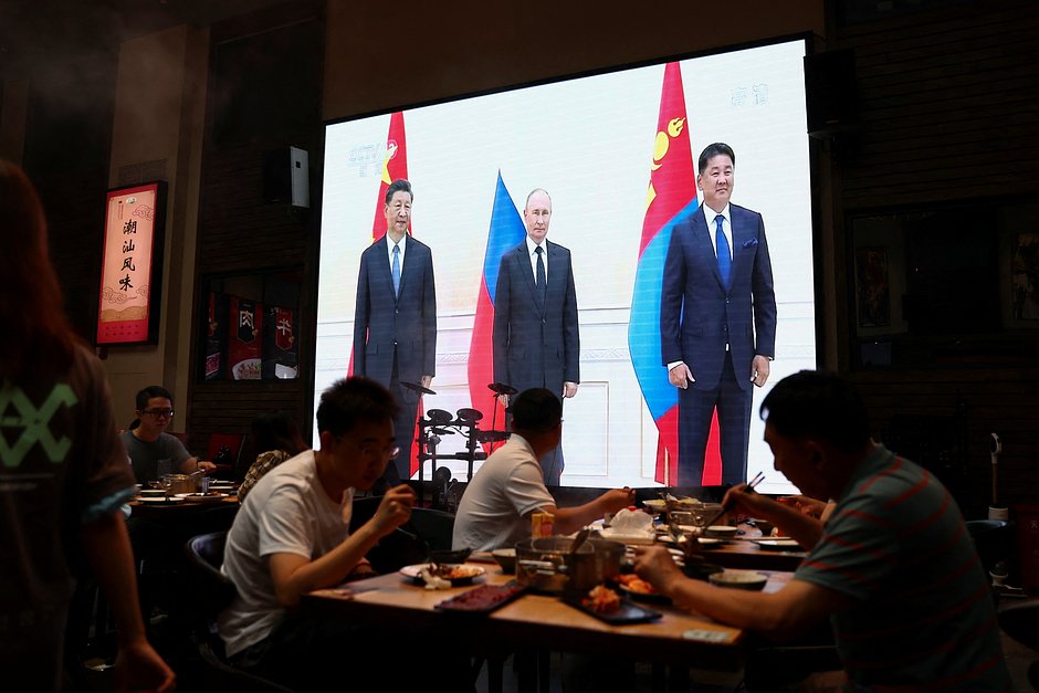 Новости о встрече председателя Китая Си Цзиньпина, президента России Владимира Путина и президента Монголии Ухнаа Хурэлсуха на полях саммита Шанхайской организации сотрудничества (ШОС) в Узбекистане транслируются в пекинском кафе. Китай, 16 сентября 2022 года