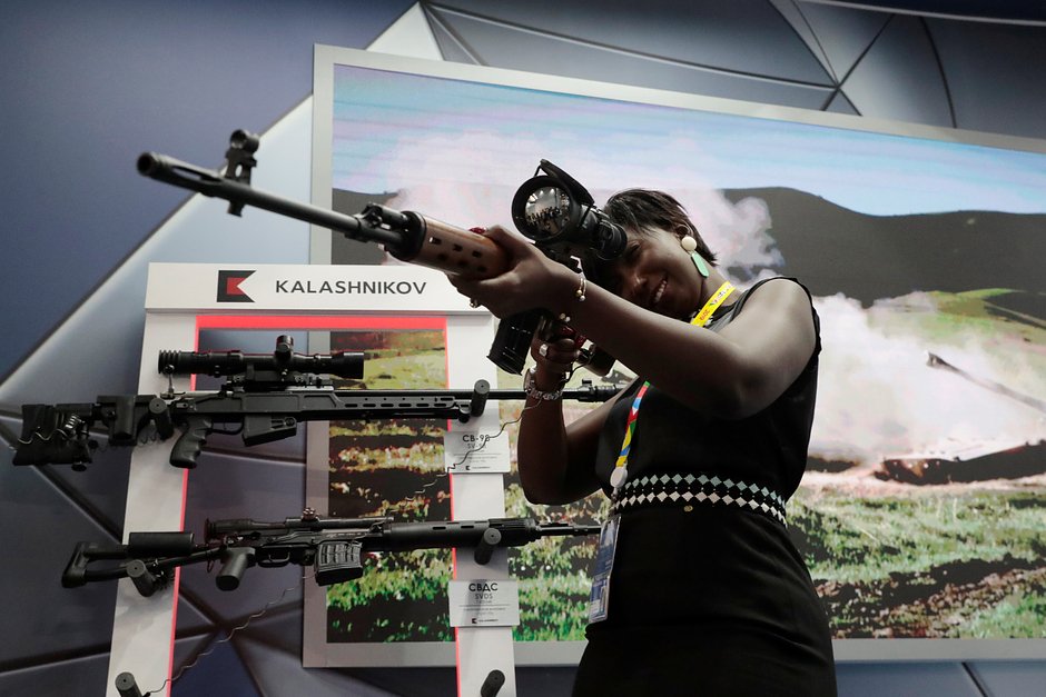 Женщина осматривает снайперскую винтовку Калашникова на выставке во время саммита «Россия — Африка», Сочи, 24 октября 2019 года