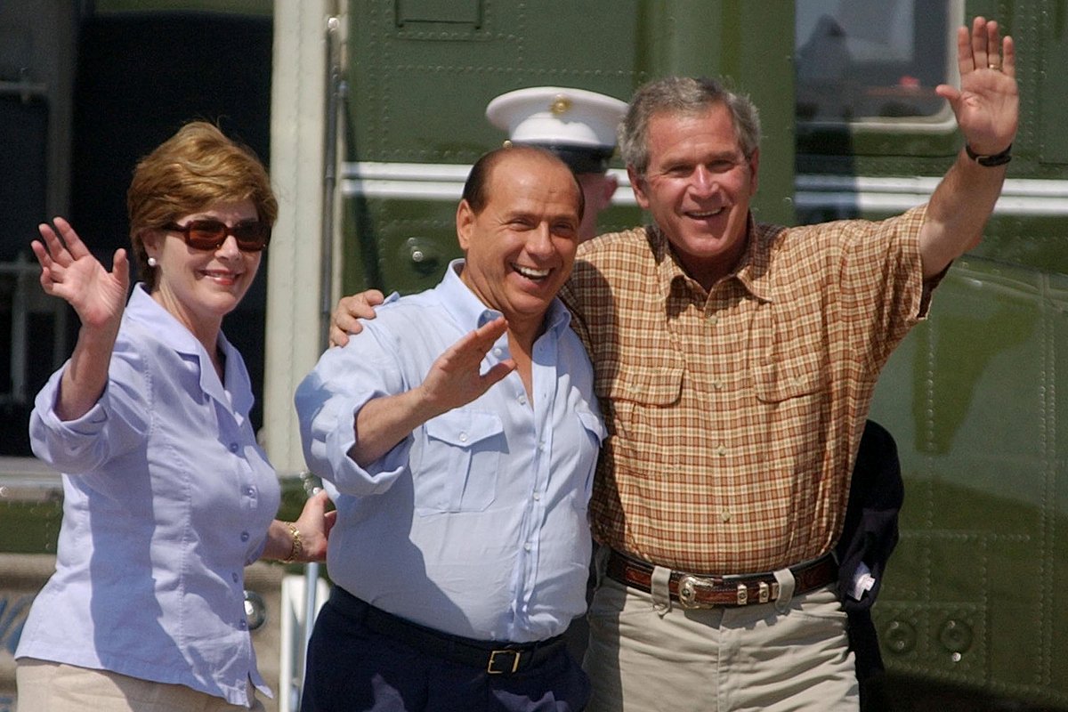 Джордж У. Буш, съпругата му Лора и Силвио Берлускони махат на фотографи в ранчото на американския президент в Тексас, 20 юли 2003 г.