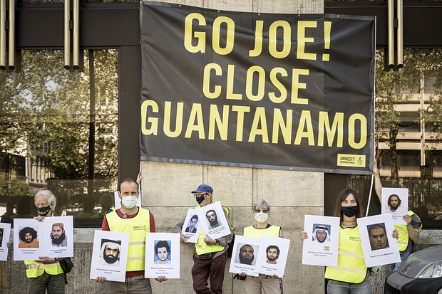 Протестующие с фотографиями людей, содержащихся в Гуантанамо, во время саммита НАТО в Брюсселе, 14 июня 2021 года. Фото: Valentin Bianchi / AP