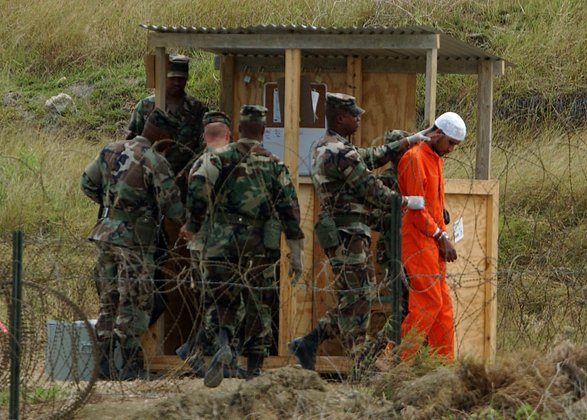 Морские пехотинцы доставляют задержанного в лагерь X-Ray в Гуантанамо, 6 февраля 2002 года. Фото: Chris Hondros / Getty Images