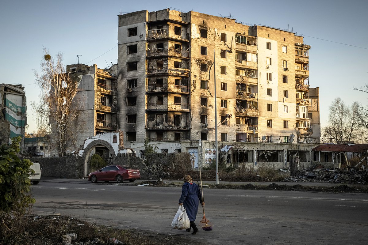 Местные жители проходят мимо поврежденных зданий в Бородянке, Киевская область, 9 ноября 2022 года