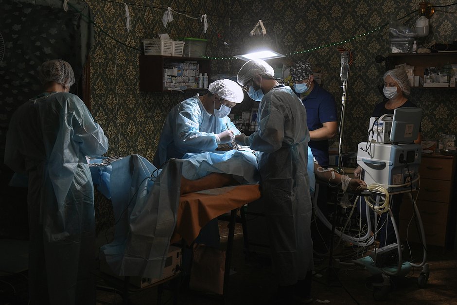 Врачи медицинского отряда специального назначения ВДВ (МОСН) оперируют раненого местного жителя в Херсонской области, 25 августа 2022 года