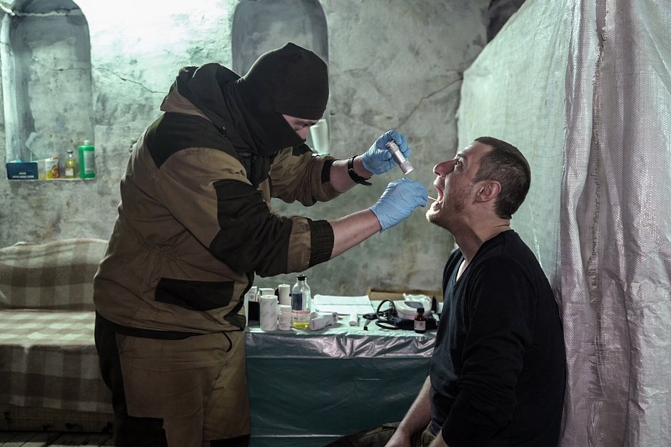 Военный врач Западного военного округа во время осмотра пациента в зоне проведения специальной военной операции, 5 февраля 2023 года
