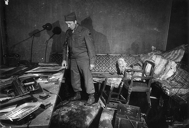 Американский военный осматривает обгоревшие помещения берлинского бункера Адольфа Гитлера