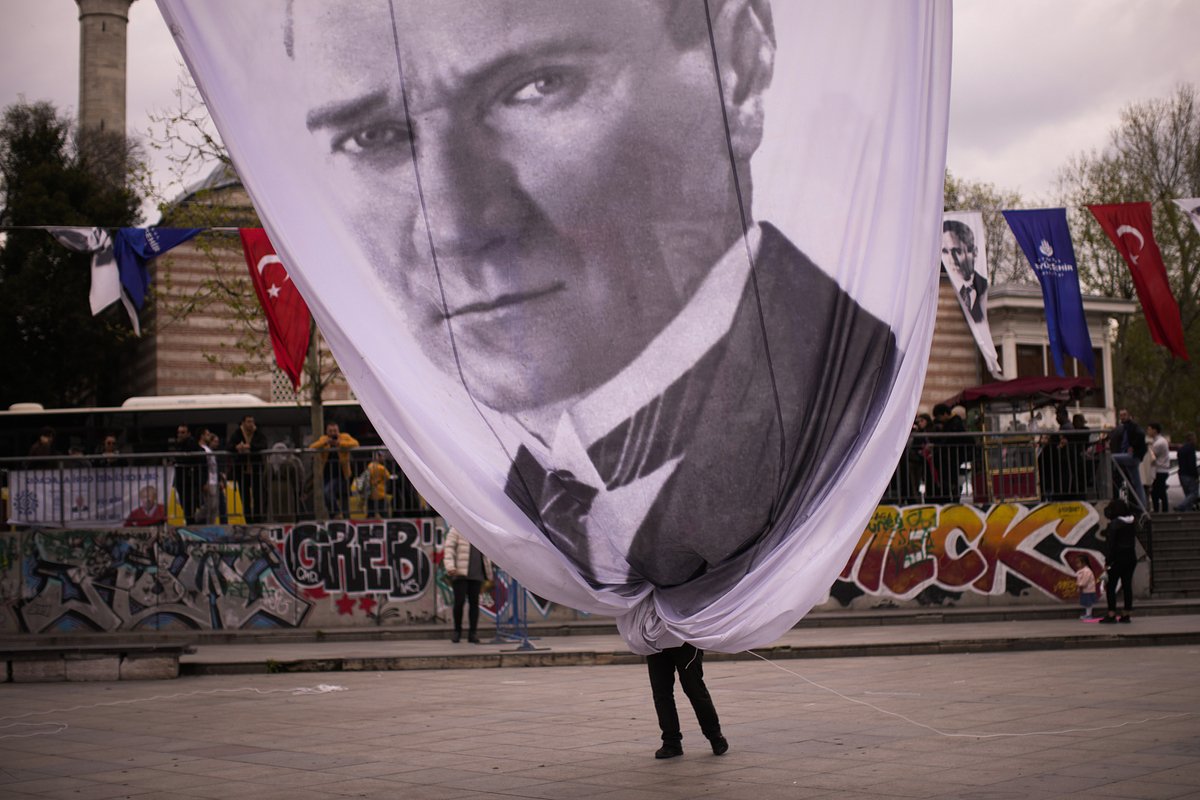 Гигантский транспарант с изображением Ататюрка, основателя современной Турции, сворачивают после окончания митинга с участием мэра Стамбула, члена оппозиционной партии НРП Экрема Имамоглу, Стамбул, 26 апреля 2023 года