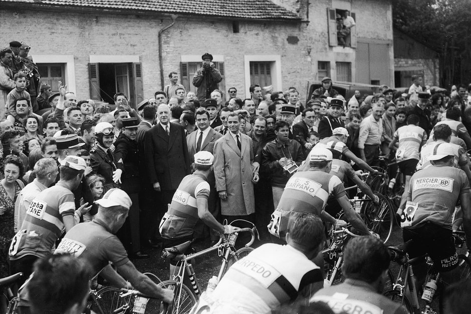 Президент Франции Шарль де Голль (в темном костюме в центре) вместе со зрителями наблюдает за велосипедистами во время этапа гонки Тур де Франс, 1960 год