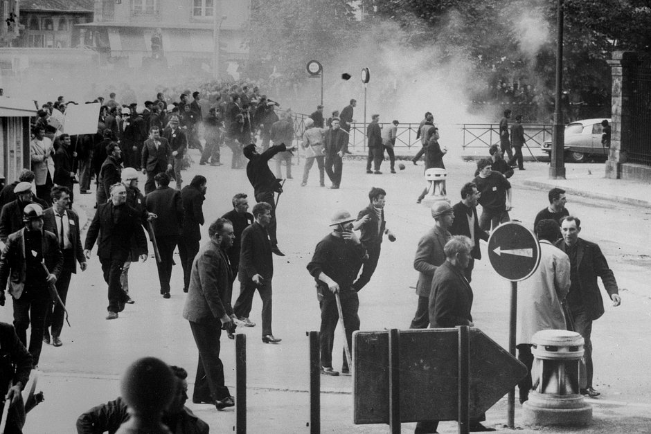 Французские студенты бросают камни в полицейских во время беспорядков в Париже, май 1968 года