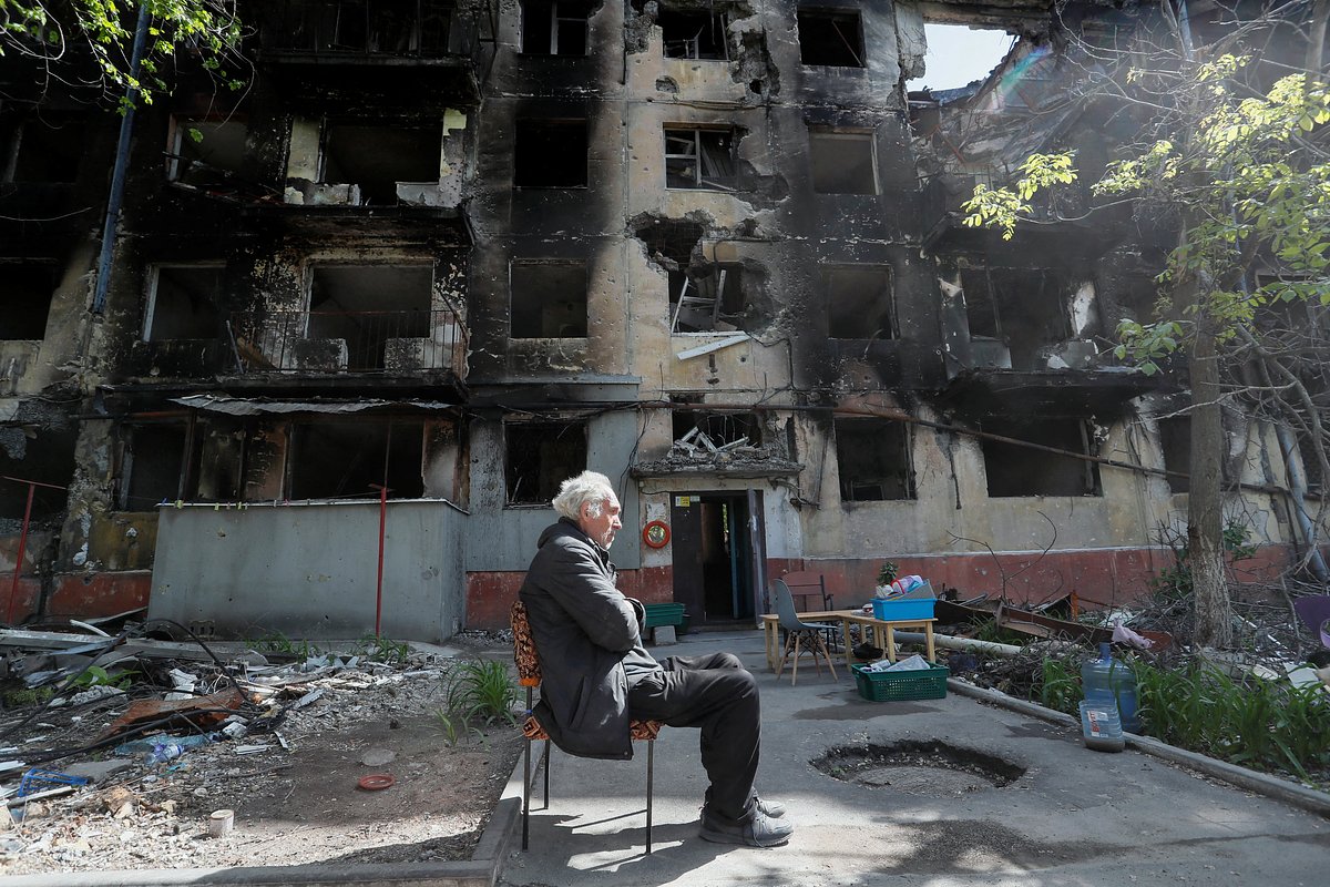 Житель города во дворе своего дома, пострадавшего во время боевых действий. Мариуполь, 20 мая 2022 года