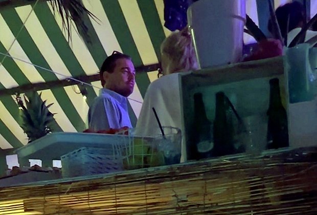 Актер Леонардо ДиКаприо беседует с неизвестной женщиной на свадьбе Джо Нахмада и Мэдисон Хедрик 