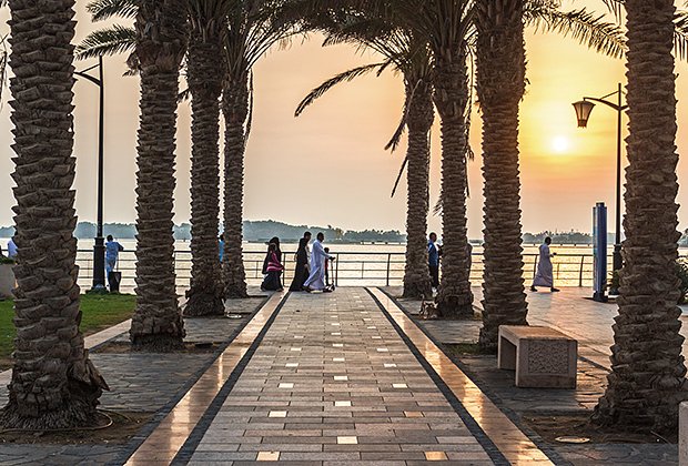 JEDDAH, SAUDI ARABIA - OCTOBER 15, 2016. Saudi Arabian people walking by Jeddah Corniche near King Fahd's Fountain in sunset