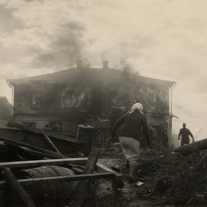 Местная жительница бежит к горящему двухэтажному дому. СССР, Украина. Лето 1941 года