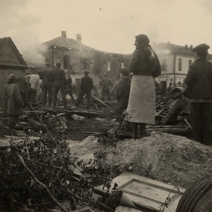 Местные жители наблюдают, как немцы пытаются потушить горящий двухэтажный дом — возможно, немецкий штаб. СССР, Украина. Лето 1941 года