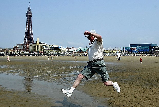 Пожилой мужчина на пляже в Блэкпуле, Англия