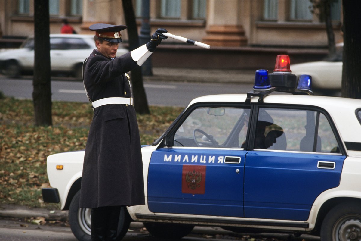 Сотрудник Госавтоинспекции Министерства внутренних дел России регулирует движение транспорта на московской улице. 1995 год