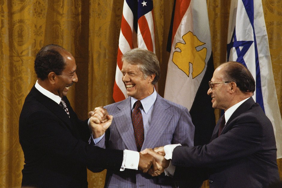 Президент Египта Анвар Садат, президент США Джимми Картер и премьер-министр Израиля Менахем Бегин взялись за руки после подписания Кэмп-Дэвидских соглашений 18 сентября 1978 года