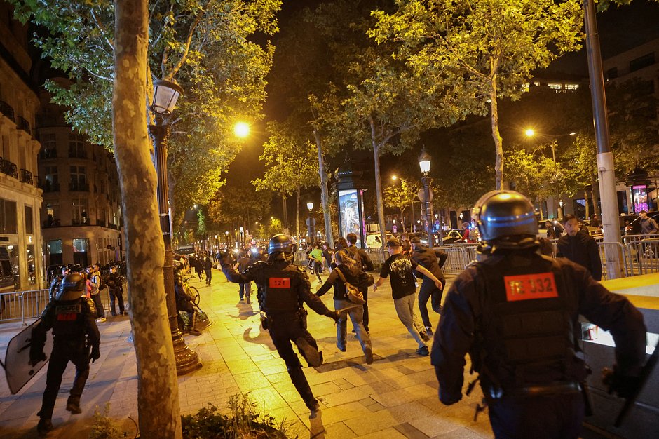 Участники протестов убегают от полицейских на Елисейских Полях в Париже, Франция, 1 июля 2023 года