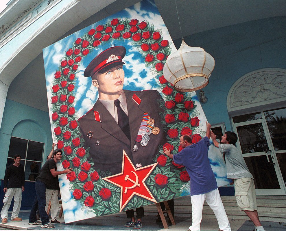 Кубинцы прячут портрет советского солдата от урагана, 3 ноября 2001 года, Гавана