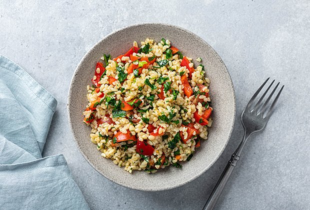 Traditional salad Tabouleh with bulgur on concrete background, top view