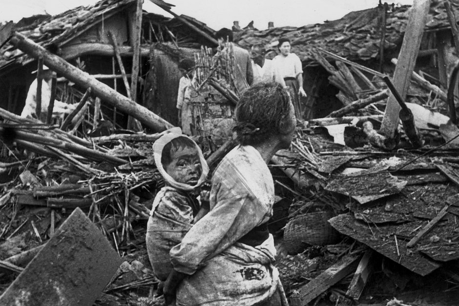 Женщина с ребенком на руинах своего дома после авианалета американской авиации на Пхеньян, 1950 год