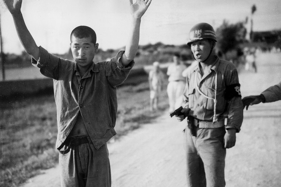 Южнокорейский полицейский держит северокорейского военнопленного под прицелом, 1953 год