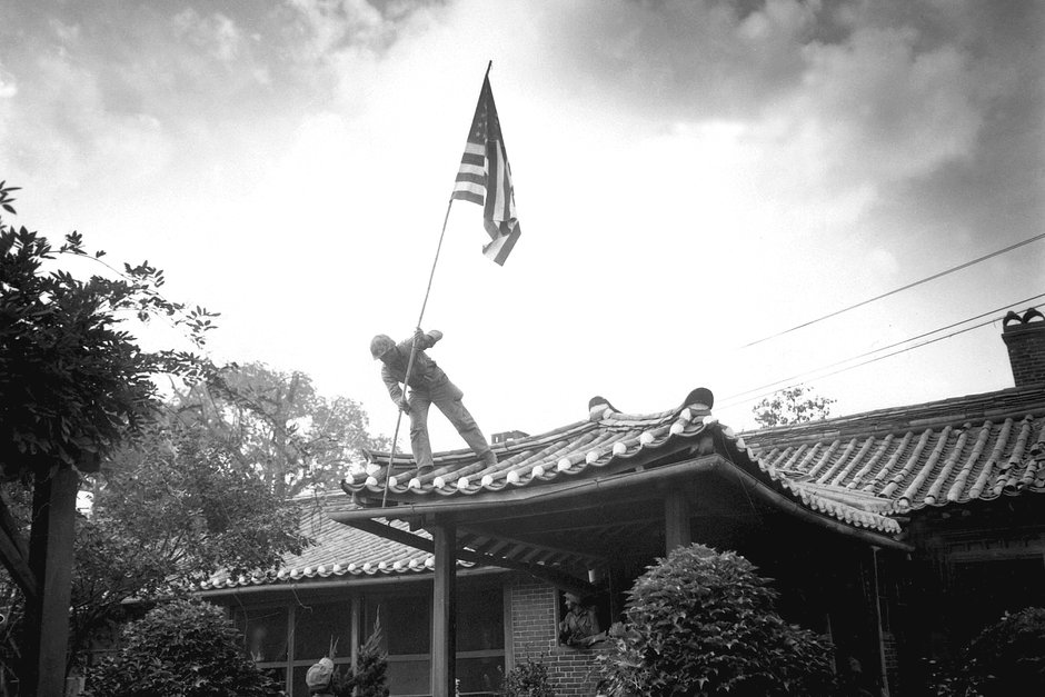Рядовой морской пехоты первого класса Лютер Легуайр поднимает американский флаг над зданием консульства США в Сеуле, Корея, сентябрь 1950 года