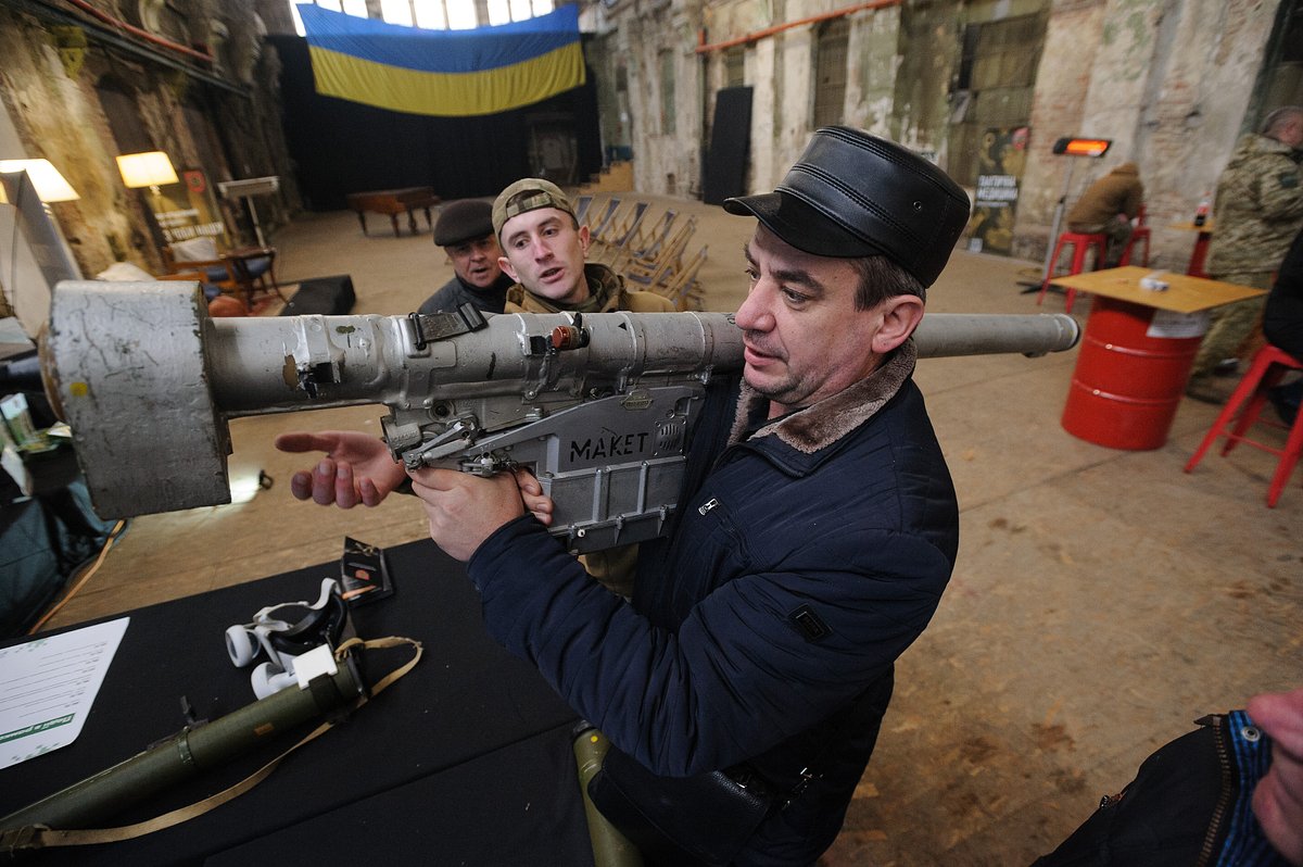 Украинский военнослужащий показывает гражданскому лицу, как обращаться с противотанковым оружием, Львов, 23 декабря 2022 года