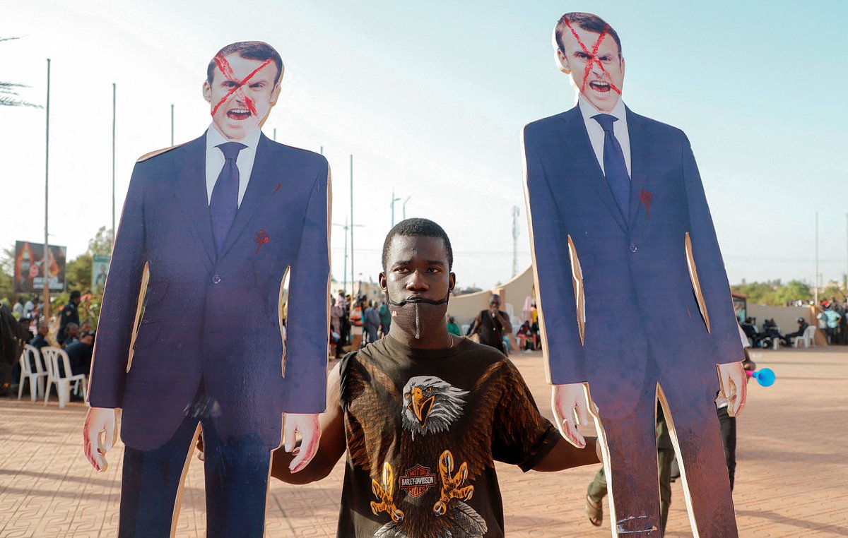 Протестующий в Мали с фигурами Эммануэля Макрона, 4 февраля 2022 года