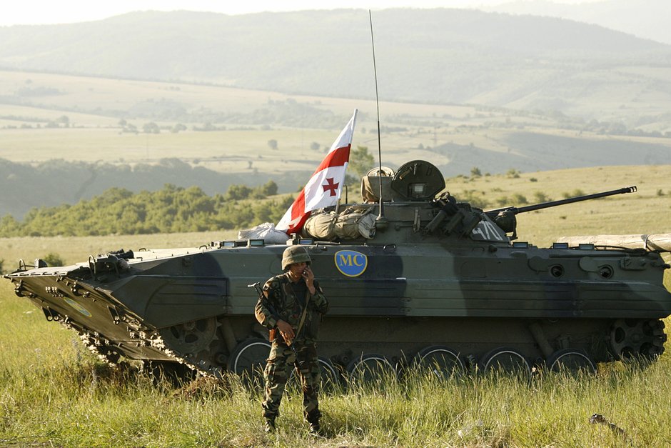 Грузинский миротворец у бронетранспортера возле села Никози, примерно в 150 километрах к северо-западу от Тбилиси, 28 июня 2007 года