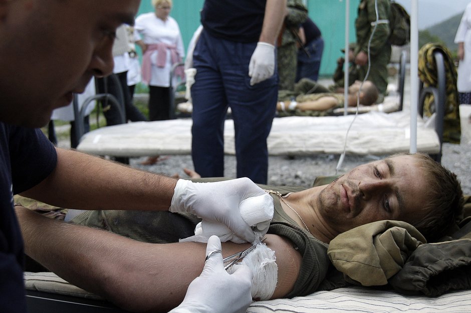Медик оказывает помощь раненому российскому солдату в больнице южноосетинского поселка Джава, 9 августа 2008 года