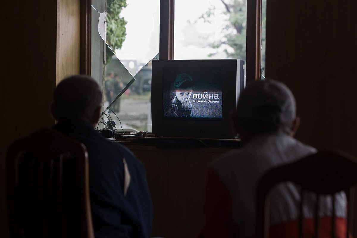 Жители Цхинвали смотрят новости из Москвы в холле разрушенной гостиницы «Алан», Южная Осетия, 13 августа 2008 года
