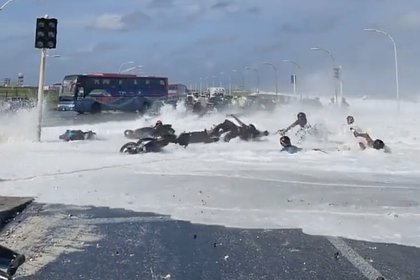 Крупная волна сбила мотоциклистов на мосту на Мальдивах и попала на видео