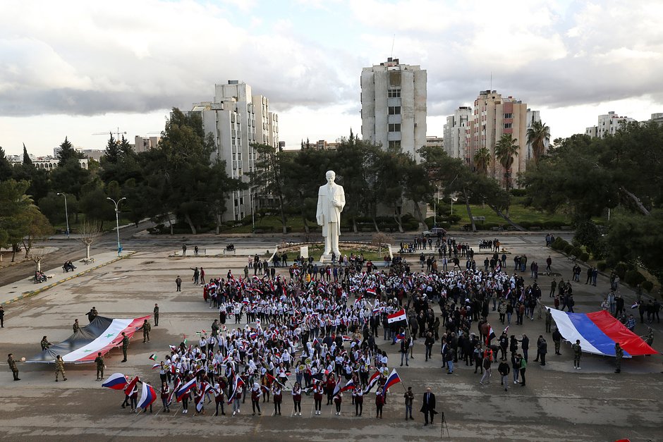 Митингующие с сирийскими и российскими флагами собираются у памятника экс-президента Сирии Хафеза Асада в Дамаске в знак солидарности с Россией после начала специальной военной операции, 9 марта 2022 года