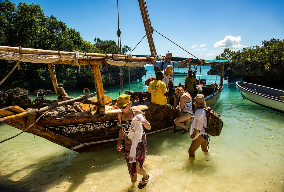 Туристы высаживаются с лодки на небольшой остров на побережье Занзибара
