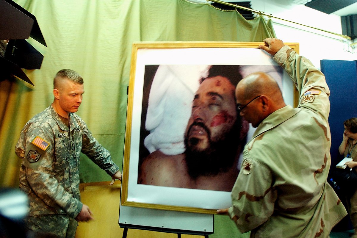 Американские солдаты несут фотографию убитого террориста Абу Мусаба аз-Заркави. Багдад, Ирак, 8 июня 2006 года 