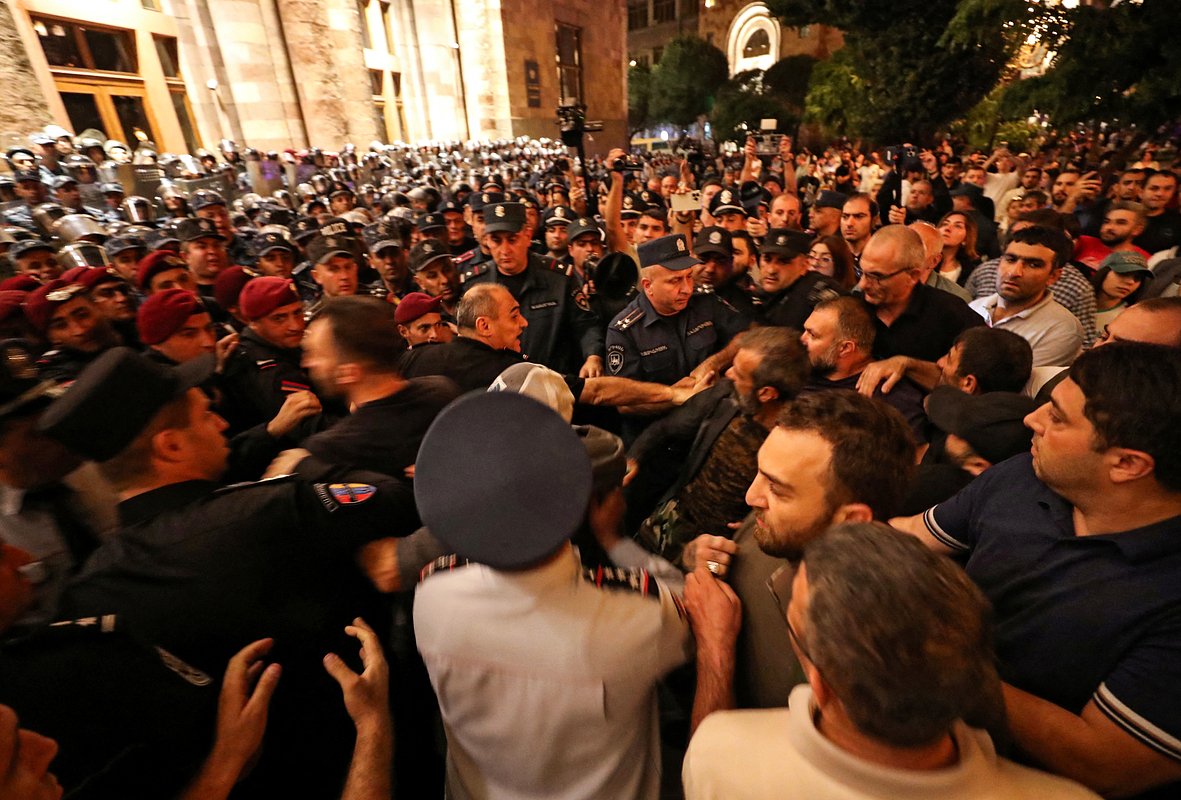 Протестующие подходят к сотрудникам правоохранительных органов, которые охраняют здание правительства во время митинга с требованием отставки премьер-министра Армении Никола Пашиняна, Ереван, 21 сентября 2023 года