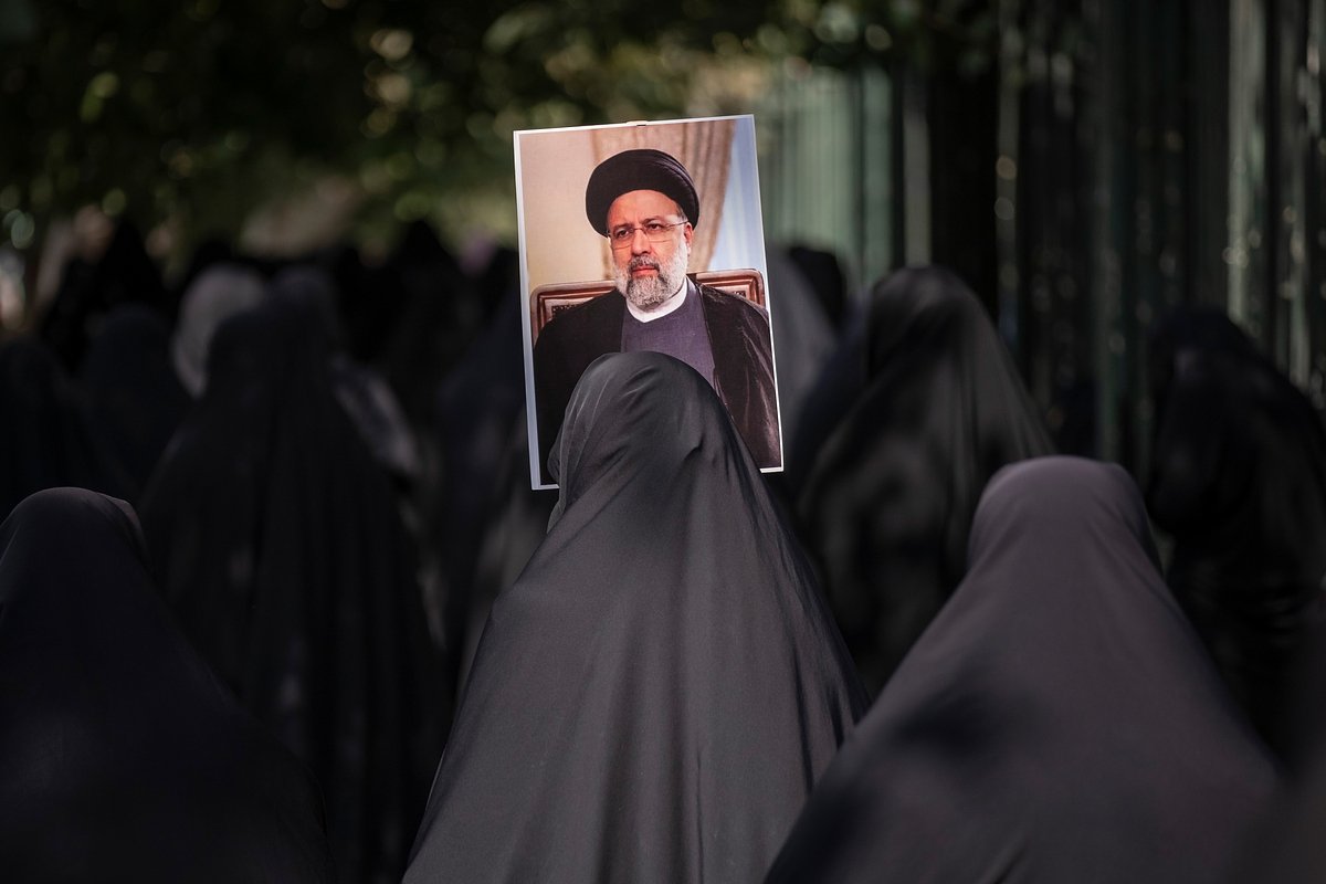Женщина в чадре несет портрет президента Ирана Эбрахима Раиси в Тегеранском университете для участия в молитвенной церемонии перед проправительственным митингом, 23 сентября 2022 года
