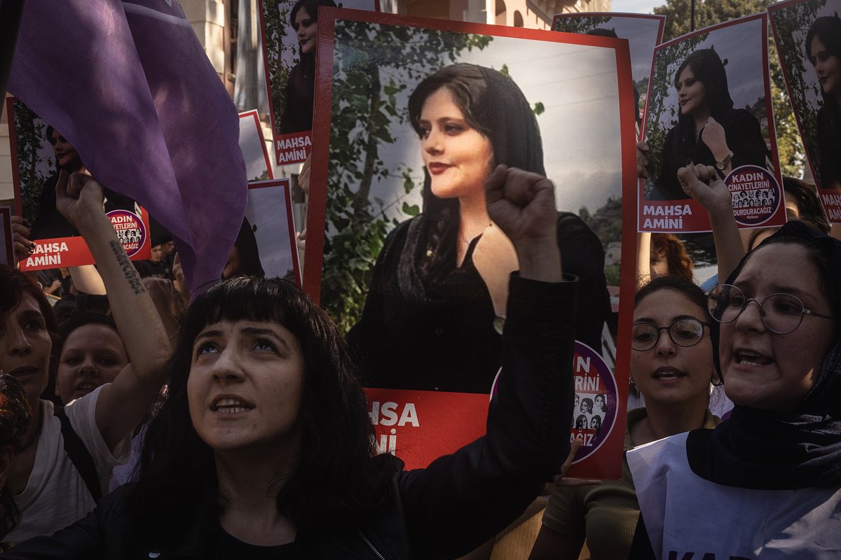 Женщины держат плакаты и скандируют лозунги во время акции протеста после смерти Махсы Амини возле консульства Ирана в Турции, Стамбул, 29 сентября 2022 года