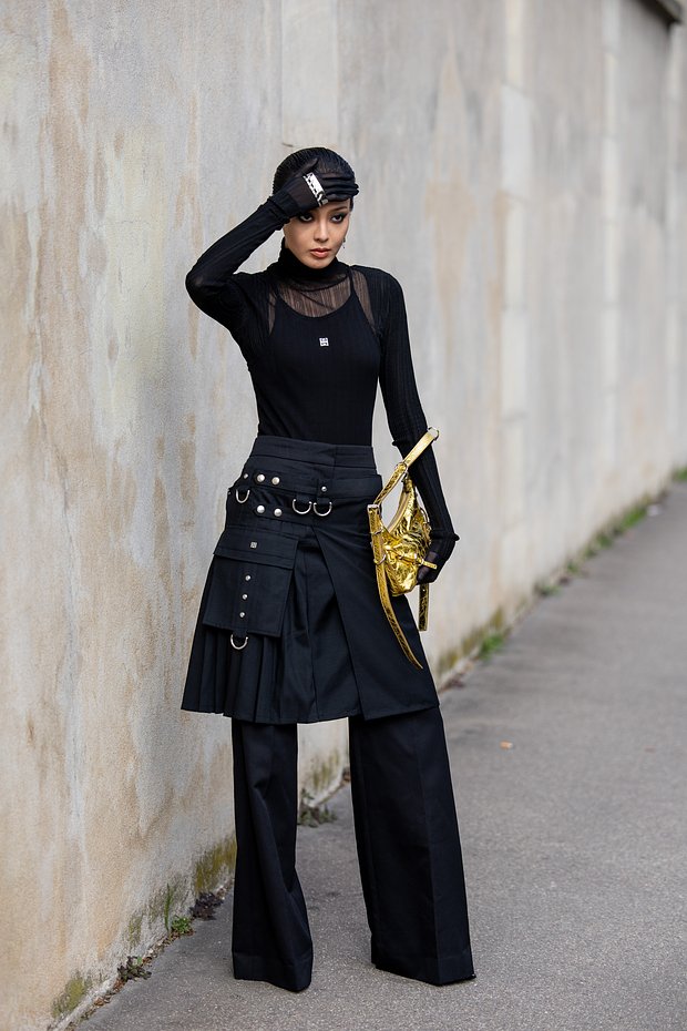 PARIS, FRANCE - SEPTEMBER 28: Kiwi Lee Han wears golden bag, black pants, turtleneck, skirt outside Givenchy during the Womenswear Spring/Summer 2024 as part of Paris Fashion Week on September 28, 2023 in Paris, France. 