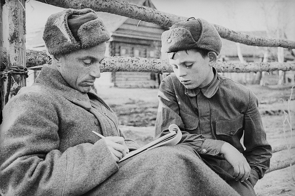 Капитан Красной армии и воспитанник части на улице освобожденной деревни. Калининский фронт, 1942 год