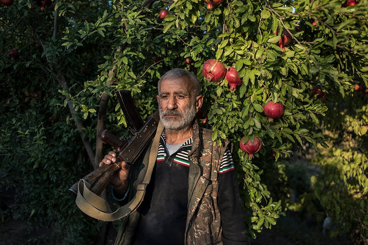 Местный житель Анушаван в гранатовом саду рядом со своим домом. В его руке — старый автомат Калашникова, который остался у него с Первой карабахской войны, 14 октября 2020 года
