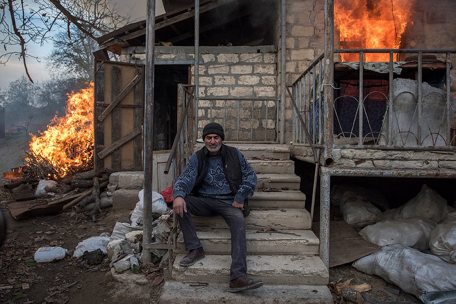 Местный житель Арег у горящего дома в поселке Карегах (Карыкаха), Нагорный Карабах. Некоторые жители сожгли свои дома перед тем, как уйти. 14 апреля 2021 года