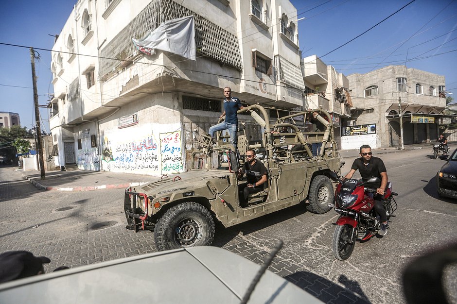 Палестинцы в израильском военном автомобиле на улицах Газы 