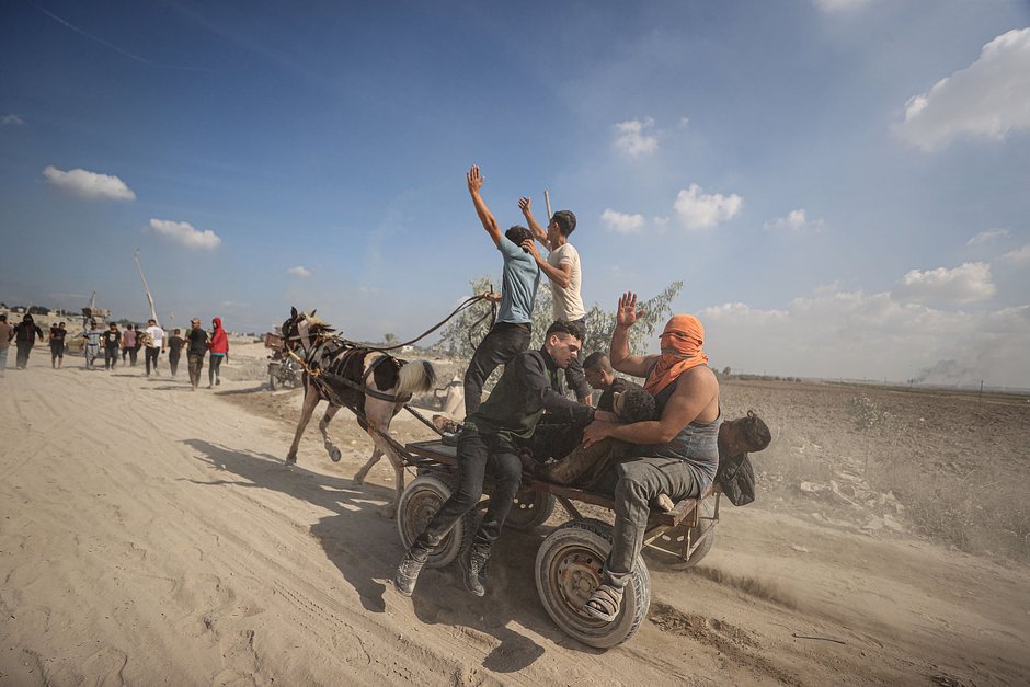 Палестинцы вывозят бойцов военного крыла ХАМАСА, раненых в столкновениях на границе сектора Газа и Израиля