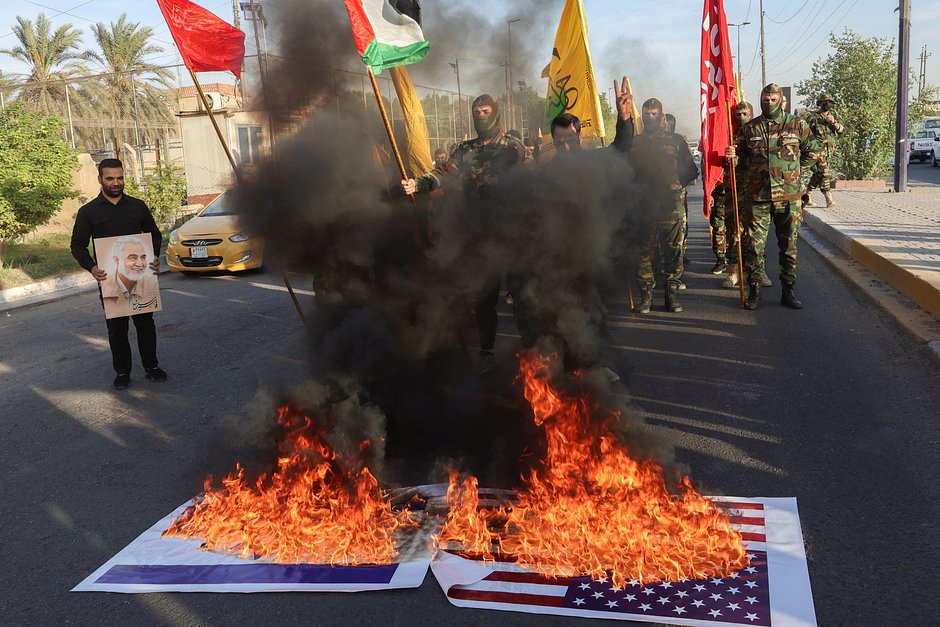 Члены иракского шиитского ополчения «Харакат Ан-Нуджаба» сжигают флаги США в знак солидарности с палестинцами в секторе Газа, Багдад, Ирак, 8 октября 2023 года