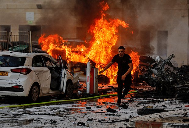 Мужчина убегает от пожара, возникшего после ракетного удара по городу Ашкелон из сектора Газа