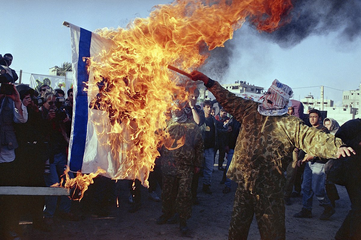 Исламские активисты в масках сжигают израильский флаг на митинге, состоявшемся в поддержку ХАМАС и против израильского правительства. 1994 год, Газа