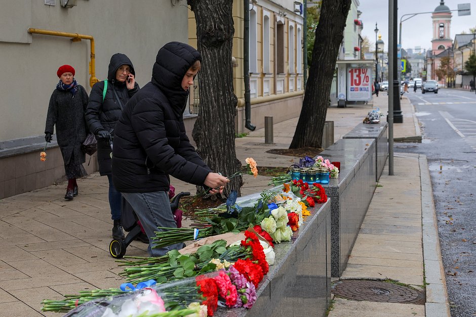 Люди возлагают цветы к импровизированному мемориалу возле посольства Израиля в России в память о жертвах после начала нападения палестинской группировки ХАМАС на Израиль, Москва, 9 октября 2023 года