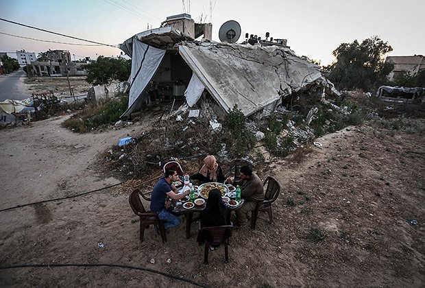 Палестинская семья, проживающая в пластиковом сарае рядом со своим домом, который был разрушен в ходе атак израильских сил в 2014 году
